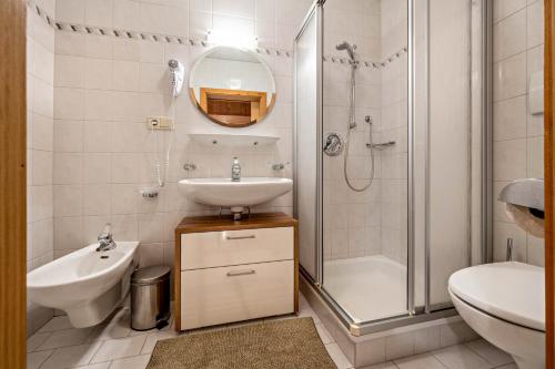 a white bathroom with a sink and a shower at Manuel's App Watschinger - Enzian in Sesto