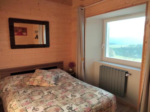 a bedroom with a bed and a window at Gîte du Bachat in Vorey