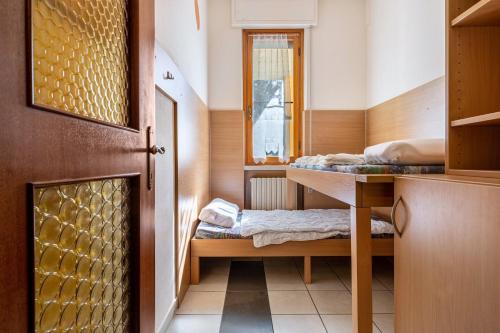 a small room with two beds and a desk at Appartamento Alexander in Tignale
