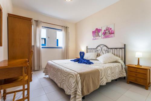 a bedroom with a bed with a blue ribbon on it at El Sombrerito 4 in Caleta de Sebo