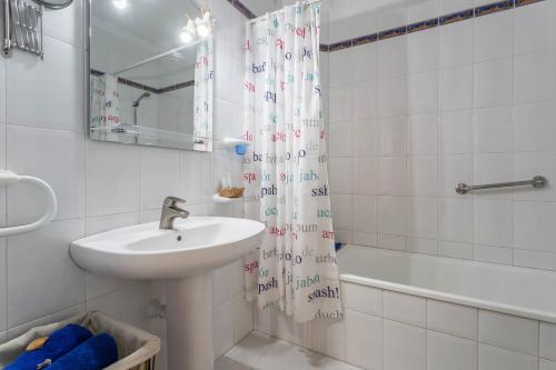 a bathroom with a sink and a shower curtain at El Sombrerito 4 in Caleta de Sebo