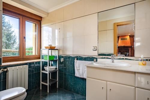 a bathroom with a sink and a toilet and a mirror at Casa Nueva in Salas