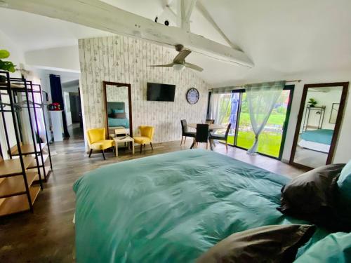 a bedroom with a large bed and a living room at La Cour de la Forêt in Saint-Mars-de-Coutais