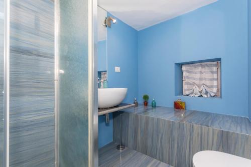a bathroom with blue walls and a sink at Domus Elisae - Taormina in Taormina