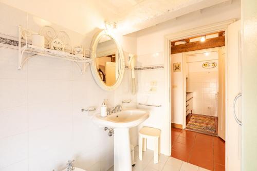 a white bathroom with a sink and a mirror at Residenza d'epoca Alcova in Lucignano