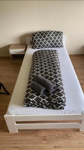 a bed with a black and white blanket and pillows at Apartment Wohner in Petersaurach