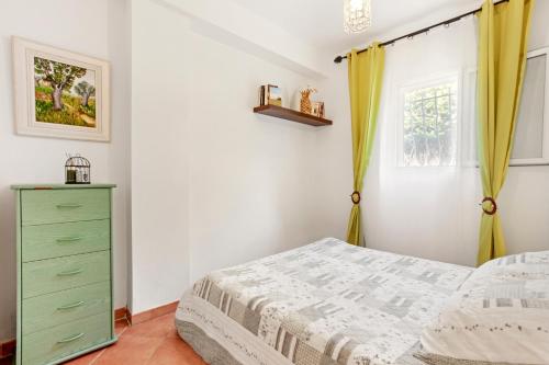 a bedroom with a bed and a green dresser at Bel appartement à Saint-Maxime in Sainte-Maxime