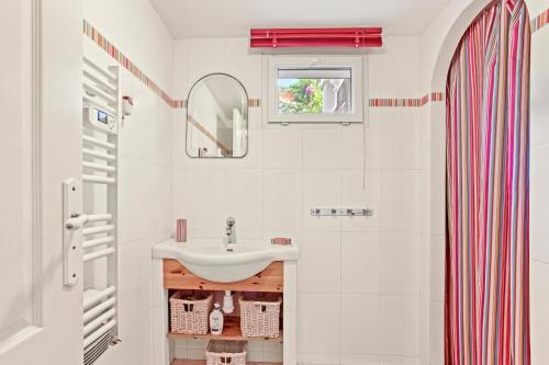 a white bathroom with a sink and a mirror at Bel appartement à Saint-Maxime in Sainte-Maxime