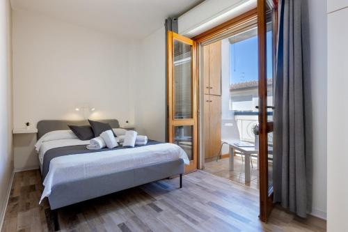 a bedroom with a bed and a large window at Max Apartment in Quartu SantʼElena