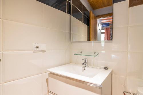 ein weißes Badezimmer mit Waschbecken und Spiegel in der Unterkunft Mossen Batista Faig in Les Iglésies