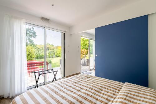 a bedroom with a blue wall and a bed at Kerwall - Maison d'hôtes in Malville