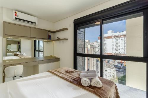 a bedroom with a bed and a large window at Soul República - Cidade Baixa in Porto Alegre