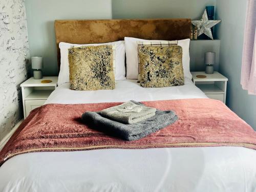 a bedroom with a bed with a red blanket and pillows at Corvette in Trearddur