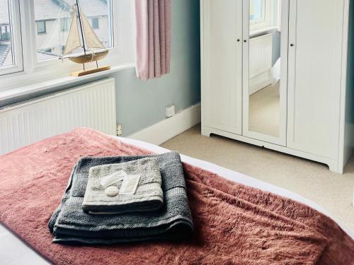 a room with a bed with a towel and a mirror at Corvette in Trearddur