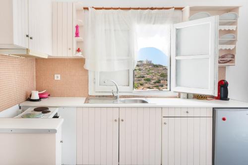 a kitchen with a sink and a window at Antiparos - Sikinos Sunset in Sikinos