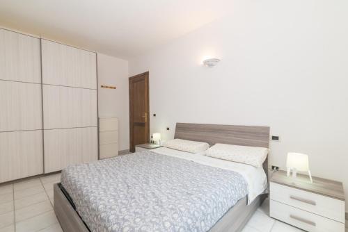 a white bedroom with a large bed and white cabinets at La Gioia in Palau
