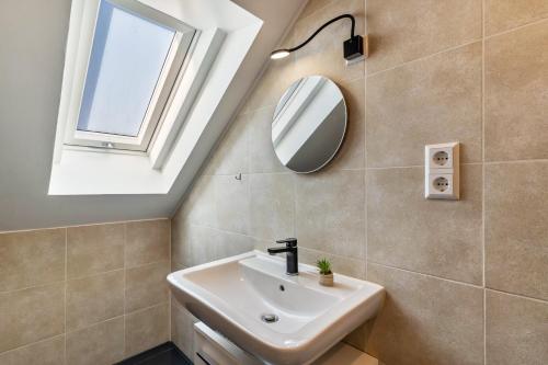 a bathroom with a sink and a mirror at Ferienwohnung Sena in Weisweil