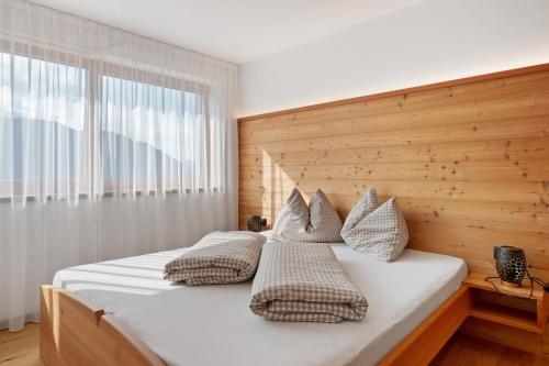 a bedroom with a bed with white sheets and pillows at Pfösslerhof in Bolzano
