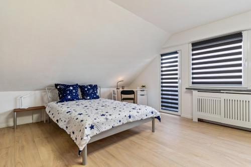 a white bedroom with a bed with blue pillows at Ferienwohnung Sena in Weisweil