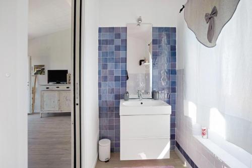 a bathroom with a white sink and blue tiles at Rosadimaggio Violetta in Arcola