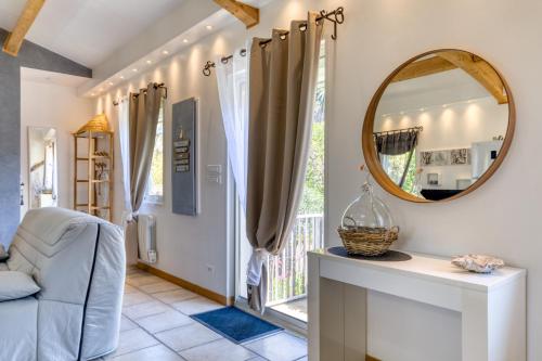 a living room with a mirror and a chair at Les Bois flottés in Poussan