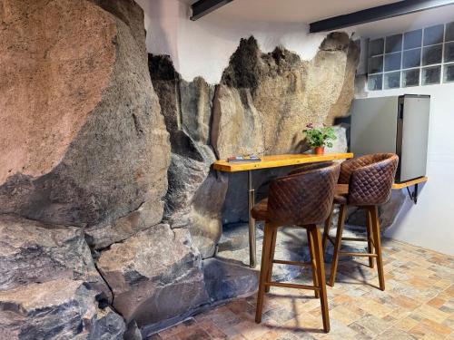 a stone wall in a kitchen with a table and two chairs at Casa Roca in Arona