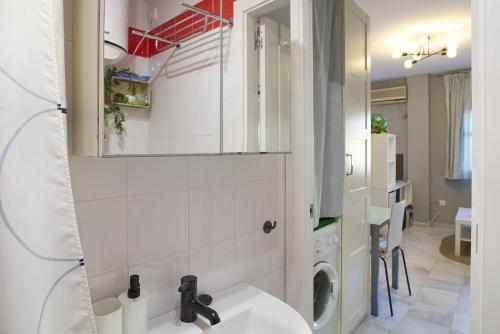 a bathroom with a sink and a washing machine at Casa Curro en Baena in Baena