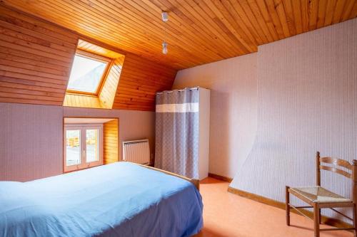 a bedroom with a bed and a window and a chair at Gite Tikilou 6 Pers proche montagne in La Tour-dʼAuvergne