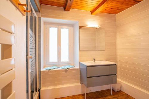 a bathroom with a sink and a window at Gite Tikilou 6 Pers proche montagne in La Tour-dʼAuvergne