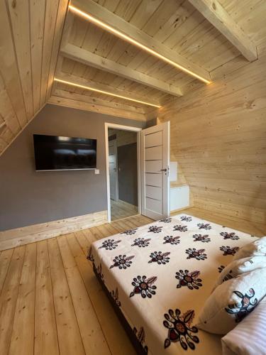 a bedroom with a bed and a tv on the wall at Apartamenty u Załogi in Zakopane