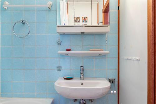 a blue tiled bathroom with a sink and a toilet at Wohnung Fuchsenstein-Foxy in Spiegelau