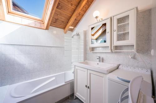 a bathroom with a sink and a toilet and a tub at La Mouliniere 1 in Valloire