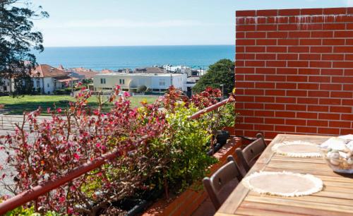 a patio with a table and some flowers and the ocean at Bahia Sea View Apartment in Caminha