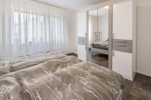 a bedroom with a large bed and a mirror at Heidis Dihei in Büsingen