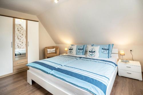 a bedroom with a large bed with blue and white pillows at Kleiner Priel in Dorum