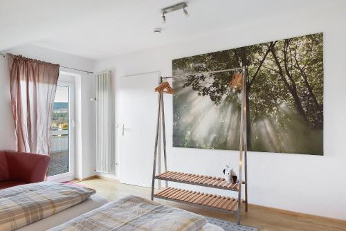 a bedroom with a large painting on the wall at Ferienwohnung Eulennestle in Lenzkirch
