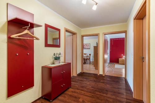 a hallway with a red cabinet and a living room at Ferienwohnung Smithson in Biberach