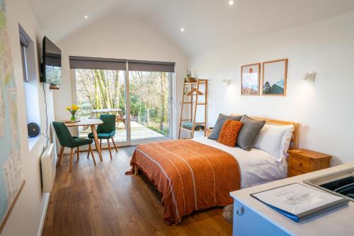 a bedroom with a bed and a table with chairs at An Bothan in Isleornsay