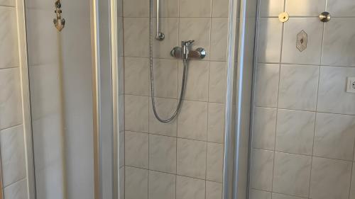 a shower with a hose in a bathroom at Ferienhaus mit Sauna am Waldrand in Friedrichroda