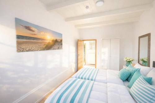a bedroom with a bed with blue and white pillows at Huus ant Dörpsdiek in Krummhörn