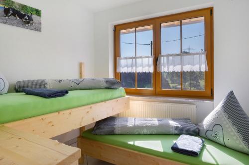 a room with two bunk beds and a window at Hinterbauernhof Fewo Kuhgeflüster in Stegen