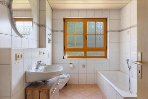 a bathroom with a sink and a tub and a toilet at Hinterbauernhof Fewo Kuhgeflüster in Stegen