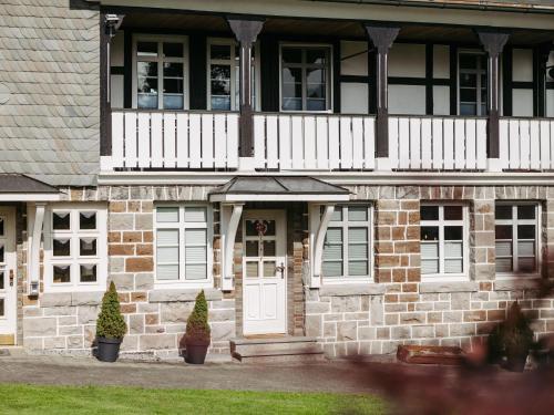 a brick building with a white door and balcony at Ferienwohnung Wennetal in Schmallenberg