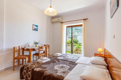 a bedroom with two beds and a table and a window at Mires House Apartment 11 in Agios Gordios