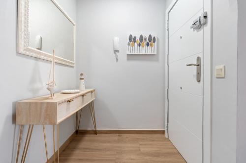 a hallway with a wooden table and a door at Apartamentos Cunidor - Cunit in Cunit