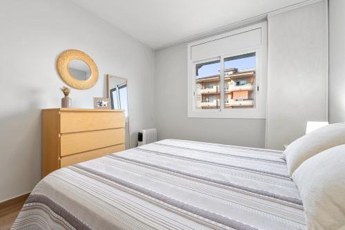 a bedroom with a bed and a dresser and a window at Apartamentos Cunidor - Cunit in Cunit