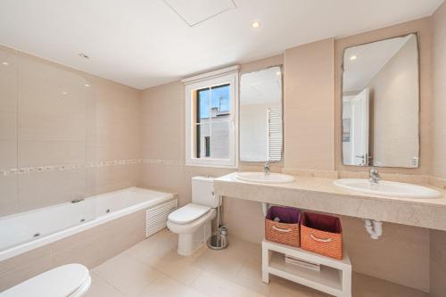 a bathroom with two sinks and a tub and a toilet at Villa Alma Azul in Llucmajor
