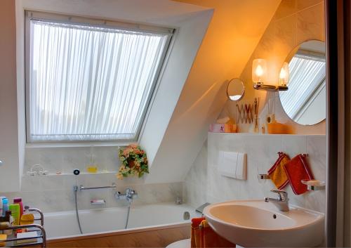 a bathroom with a sink and a bath tub and a window at Haus Wehrle in Breisach am Rhein