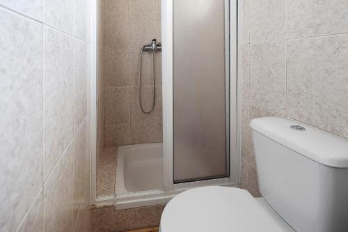 a bathroom with a shower and a toilet and a tub at Casa Ponta do Biscoito in Lajes do Pico