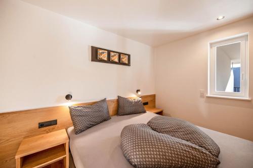 a bedroom with a large bed with a window at Thalerhof Sancta Sebastianus in Auna di Sotto